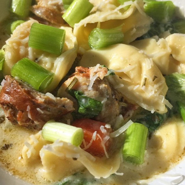 White creamy tortellini soup with sausage.